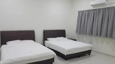 two beds in a room with white sheets at My STW Home 2 in Sitiawan