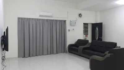 a living room with a couch and a gray curtain at My STW Home 1 in Sitiawan