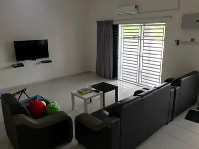 a living room with couches and a table and a tv at My STW Home 1 in Sitiawan