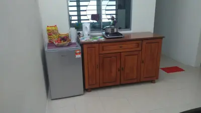 a kitchen with a counter and a refrigerator in a room at MaiHomestay Seri Iskandar in Seri Iskandar