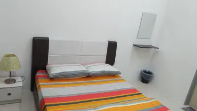 a bedroom with a bed with a colorful striped blanket at MaiHomestay Seri Iskandar in Seri Iskandar