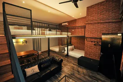 a room with a couch and a loft bed at Iconic Suites & Pods Hotel in Ipoh
