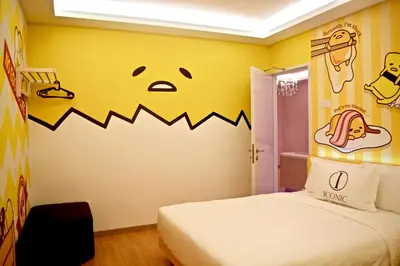 a bedroom with a bed and a yellow wall at Iconic Suites & Pods Hotel in Ipoh