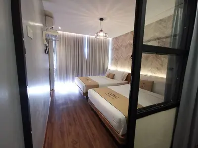 a small room with two beds and a window at Iconic Suites & Pods Hotel in Ipoh