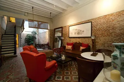 a living room with red chairs and a brick wall at Muntri Mews in George Town