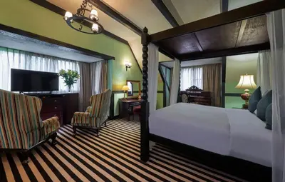 a bedroom with a bed and a desk and a television at The Lakehouse Cameron Highlands in Ringlet