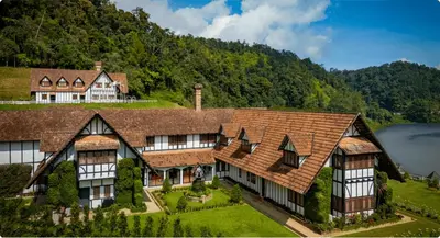 a large house with a mountain in the background at The Lakehouse Cameron Highlands in Ringlet