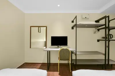a bedroom with a desk with a computer and a bunk bed at Collection O GHC Near Penang Street Art Formerly Queen City Hotel in George Town