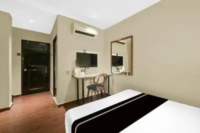 a hotel room with a bed and a desk at Collection O GHC Near Penang Street Art Formerly Queen City Hotel in George Town