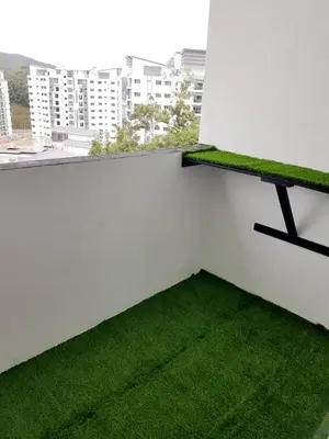a balcony with green grass on a white wall at Triple J in Cameron Highlands
