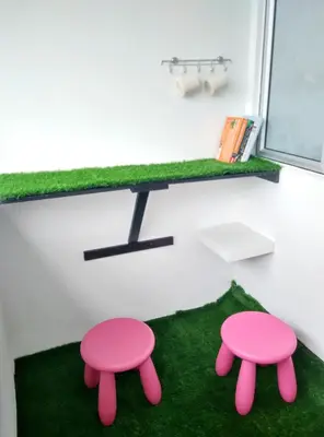a room with two pink stools on a green rug at Triple J in Cameron Highlands