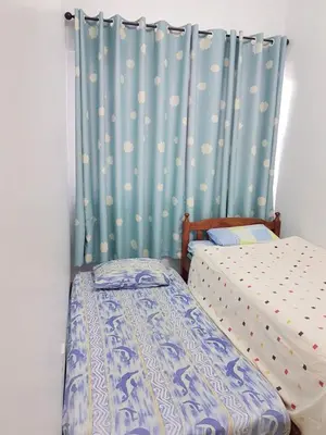 a bedroom with two twin beds and a curtain at Triple J in Cameron Highlands