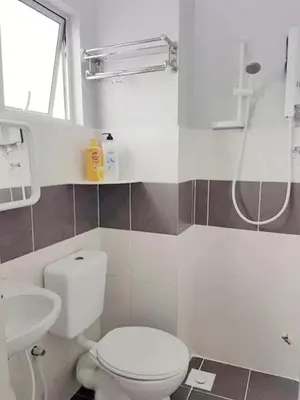 a bathroom with a white toilet and a sink at Triple J in Cameron Highlands