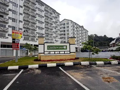 a parking lot with a sign in front of a building at Triple J in Cameron Highlands