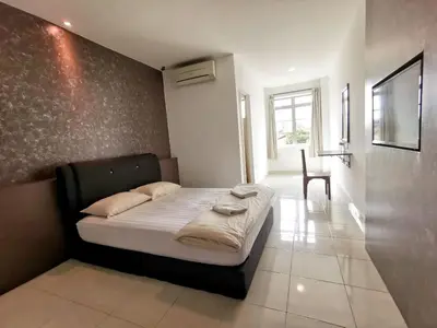 a bedroom with a bed and a chair in it at Potato Hotel in Taiping