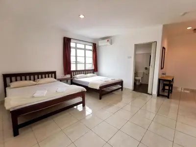 a bedroom with two beds and a bathroom at Potato Hotel in Taiping