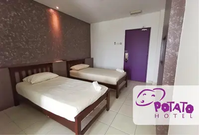 a hotel room with two beds and a purple door at Potato Hotel in Taiping