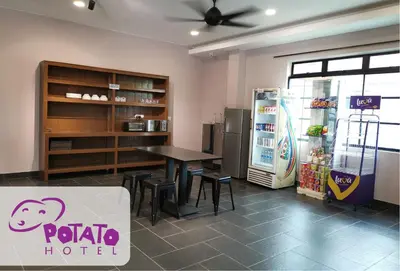 a restaurant with a table and a refrigerator at Potato Hotel in Taiping