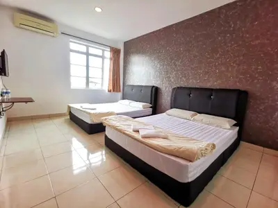 a bedroom with two beds and a wall at Potato Hotel in Taiping