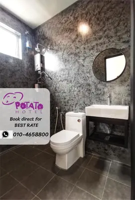 a bathroom with a white toilet and a sink at Potato Hotel in Taiping