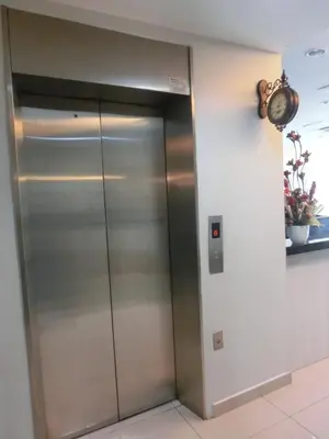 an elevator in a building with a clock on the wall at BG Business Hotel in Bukit Mertajam