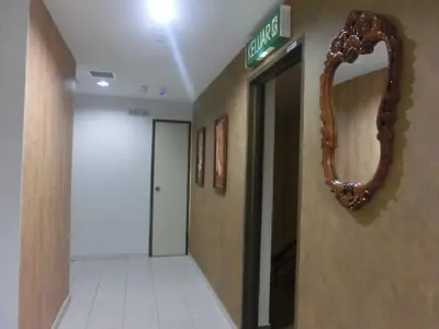 a hallway with a mirror on the wall of a building at BG Business Hotel in Bukit Mertajam