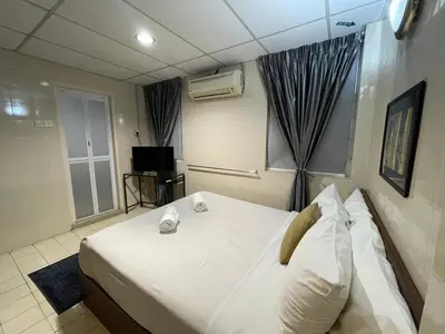 a bedroom with a large white bed and a window at Barrack Street Hotel in Taiping