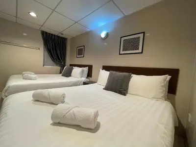 a hotel room with two beds with towels on them at Barrack Street Hotel in Taiping