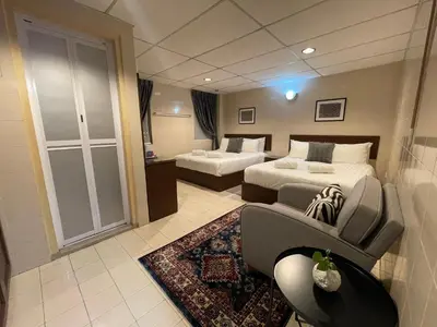 a hotel room with two beds and a couch at Barrack Street Hotel in Taiping