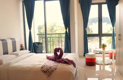a bedroom with two beds and a large window at ATS Cameron Hotel & Apartments in Cameron Highlands