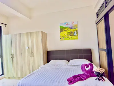 a bedroom with a bed with a pink ribbon on it at ATS Cameron Hotel & Apartments in Cameron Highlands