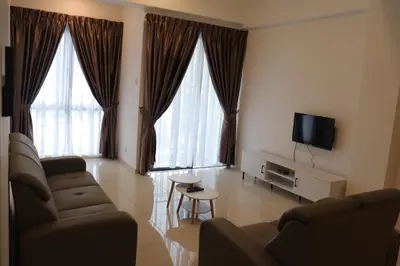 a living room with a couch and a tv and two windows at ATS Cameron Hotel & Apartments in Cameron Highlands