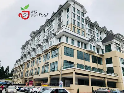 a large building with cars parked in a parking lot at ATS Cameron Hotel & Apartments in Cameron Highlands
