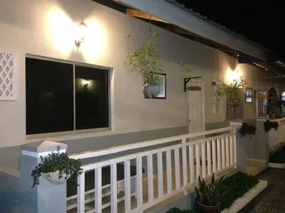 a house with potted plants on the side of it at Nipah Guesthouse Pangkor in Pangkor