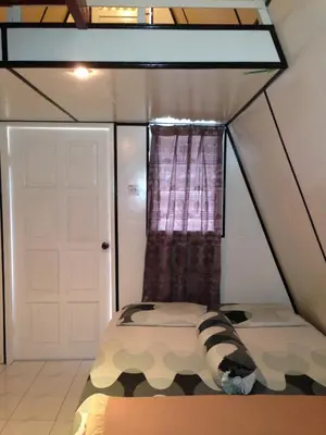 a bedroom with a camouflage bed and a window at Nipah Guesthouse Pangkor in Pangkor