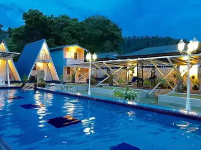 a hotel swimming pool at night at Nipah Guesthouse Pangkor in Pangkor
