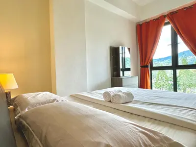 two beds in a room with a window at Themework Homestay@Cameron Highlands in Cameron Highlands