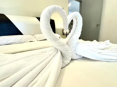 two white swans are standing on a bed at Themework Homestay@Cameron Highlands in Cameron Highlands