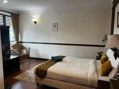 a hotel room with a bed and a chair at Melur Inn in Cameron Highlands