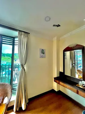 a living room with a mirror and a window at Melur Inn in Cameron Highlands