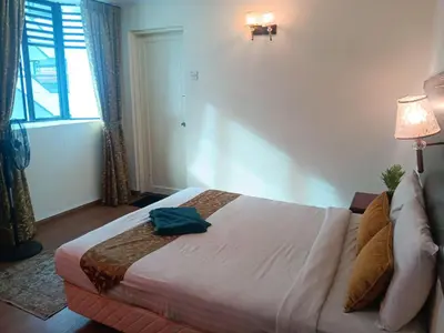 a bedroom with a bed and a lamp and a window at Melur Inn in Cameron Highlands