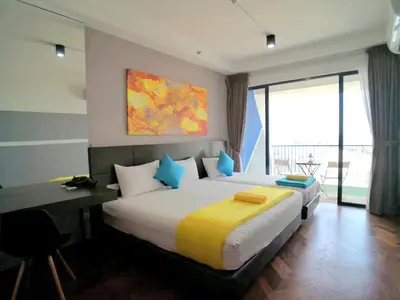 a bedroom with a large bed and a desk and window at The Landmark Pulau Andaman Gurney Bay View in George Town