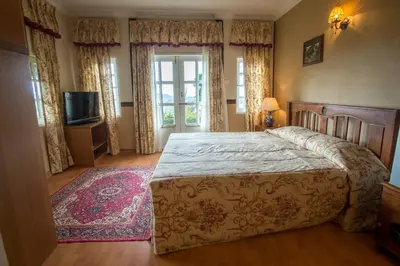 a bedroom with a large bed and a window at The Bala's Holiday Chalet in Cameron Highlands