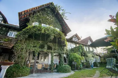 a building covered in ivy in a yard at The Bala's Holiday Chalet in Cameron Highlands