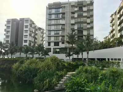 a view of buildings and a river with palm trees at By The Sea Suite,Batu Ferringhi in Batu Ferringhi