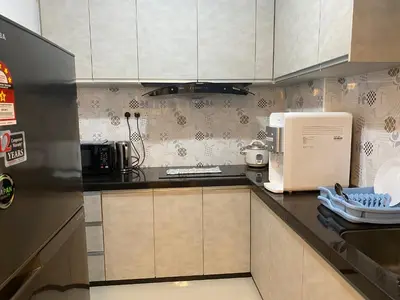 a kitchen with white cabinets and a refrigerator at The View Feringghi Executive Apartment in Batu Ferringhi