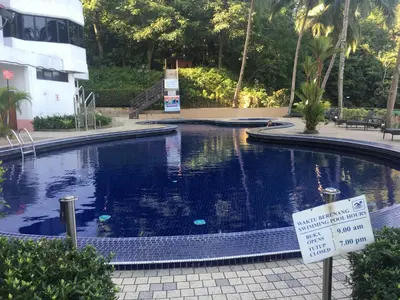 a large swimming pool with a sign in front of it at The View Feringghi Executive Apartment in Batu Ferringhi