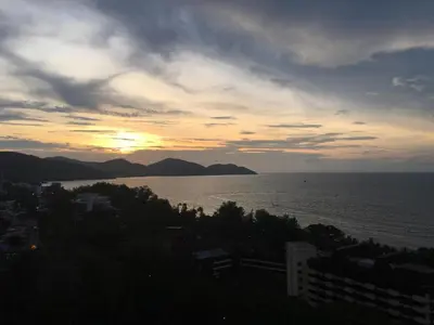 a view of the ocean with the sunset in the background at The View Feringghi Executive Apartment in Batu Ferringhi