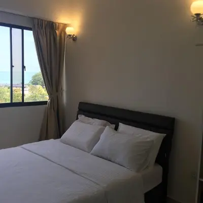 a bedroom with a white bed with a window at The View Feringghi Executive Apartment in Batu Ferringhi