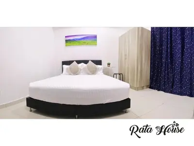 a bedroom with a large white bed with blue curtains at Rata House in Cameron Highlands